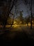 As night falls, a subtle dusting of snow transforms the city park