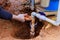 As part of repair work, technician plumber uses specialized scissors to cut a plastic PVC pipe