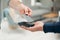 As simple as a tap. Closeup shot of an unrecognizable man paying his bills via wireless card reader.