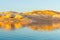 As sunsets light hits the rock embankments with a golden glow on other side Lake Powell a man-made reservoir on the Colorado River