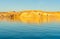 As sunsets light hits the rock embankments with a golden glow on other side Lake Powell a man-made reservoir on the Colorado River