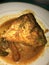 Asam pedas fish curry set on plate. Indonesian food