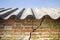 Asbestos roof above a cracked brick wall