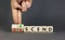 Ascend or descend symbol. Concept words Ascend and Descend on wooden cubes. Beautiful grey table grey background. Businessman hand