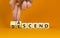 Ascend or descend symbol. Concept words Ascend and Descend on wooden cubes. Beautiful orange table orange background. Businessman