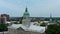 ascending aerial footage of the blue dome on top of Athens City Hall surrounded by office buildings, churches, apartments