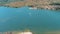 ascending aerial footage of a boat sailing across the rippling blue waters of Silverwood Lake with mountains
