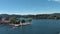 ascending aerial footage Lake Arrowhead Village with rippling blue lake water, boats and yachts, mountains