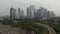 Ascending aerial pedestal shot passing the overpass with busy car traffic and revealing Jakarta city cityscape with