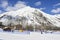 Ascending conveyor belt to a beginners run for children and parents in ski resort with mountains in background