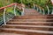 Ascending hillside planked stairway with colorful steel railings