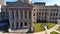 Ascending shot of the Georgia Capitol Museum with statues and lush green grass and plants in the courtyard, cars driving