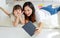 Asia black hair little cute girl and young beautiful mother lay down together smiling on white fluffy soft carpet floor watching