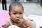 Asia Chinese little boy toddler child sit on child dinning-table board eat food with hands messy dirt on face