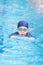 Asia cute boy wearing swimming suit and goggles used foam to practice swimming in swimming pool. Healthy kid enjoying active