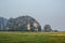 Asia farmer goes across the field on a background of mountains