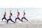 Asia people group making warrior pose on beach, fitness, sport, yoga and healthy lifestyle