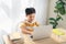 Asia preteen boy studying online on laptop with smiling and fun face at home. online education and e-learning concept
