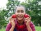 Asia senior woman holding red apple at public park.