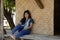 Asia thai woman travel visit and sitting on patio of bamboo and straw hut posing for take photo in Sing Buri, Thailand