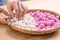 An Asia woman is making Tang yuan, yuan xiao, Chinese traditional food rice dumplings in red and white for lunar new year, winter