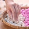 An Asia woman is making Tang yuan, yuan xiao, Chinese traditional food rice dumplings in red and white for lunar new year, winter