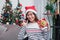 Asia woman wear santa hat and holding gift box and use mobile talk with friend and sitting on sofa in christmas party,holiday