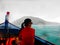 Asia woman wearing red shirt sitting on longtail boat while rain