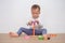 Asian 18 months / 1 year old toddler baby boy child play with colorful wooden pyramid toy / stacking ring toy