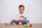 Asian 18 months / 1 year old toddler baby boy child play with colorful wooden pyramid toy / stacking ring toy