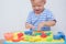 Asian 18 months old toddler baby boy child having fun playing modeling clay / play dought