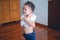 Asian 2 - 3 years old toddler boy child concentrate on putting on shirt at home