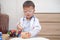 Asian 2 - 3 years old toddler boy child in doctor uniform playing doctor with plush toy at home