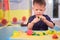 Asian 2 - 3 years old toddler boy child having fun playing colorful modeling clay / Play dough at home, Educational toys for kid