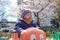 Asian 2 -3 years old toddler boy child riding red spring rider or rocker in playground with sakura cherry blossom