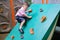 Asian 2 - 3 years old toddler child having fun trying to climb on artificial boulders at schoolyard playground, Little boy