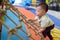 Asian 2 years old toddler baby boy child having fun trying to climb on jungle gym at indoor playground