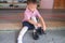 Asian 3 - 4 years old kindergarten kid in uniform sitting and concentrate on putting on children`s classics boys black leather