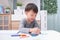 Asian 3 - 4 years old toddler boy child coloring with crayons at home, improve focus in child concept