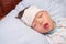 Asian 3 - 4 years old toddler boy child gets high fever lying on bed with cold compress, wet washcloth on forehead to relieve pain