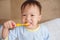 Asian 30 months / 2 year old toddler boy child wearing pajama sitting in bed holding toothbrush