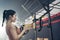 Asian active athlete girl straight out her arms to hold rope anchored to a steel beam in stadium. Sportswoman Lifting up and down