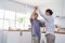 Asian active senior couple enjoy dancing together in kitchen at home. Elderly older grandfather and grandmother smiling feeling in