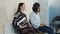 Asian and african american women talking in waiting lobby at job interview