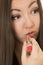 Asian American teen applying red lipstick portrait close up