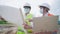 Asian architecture and engineer workers wear safety vest and hard hat aworking together at outdoor construction site, Safety first