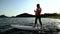 Asian athletic woman on stand paddle board in lake. Solo outdoor SUP activity and water sport on summer holiday