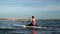 Asian athletic woman on stand paddle board in lake. Solo outdoor SUP activity and water sport on summer holiday