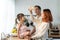 Asian attractive parents playing airplane toy with baby kid in kitchen. Happy family, young couple mother and father spend time on