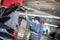 Asian auto mechanic checking the car using tablet